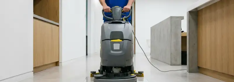 Janitorial staff using a floor scrubber machine to clean a commercial hallway, Ogden, UT.